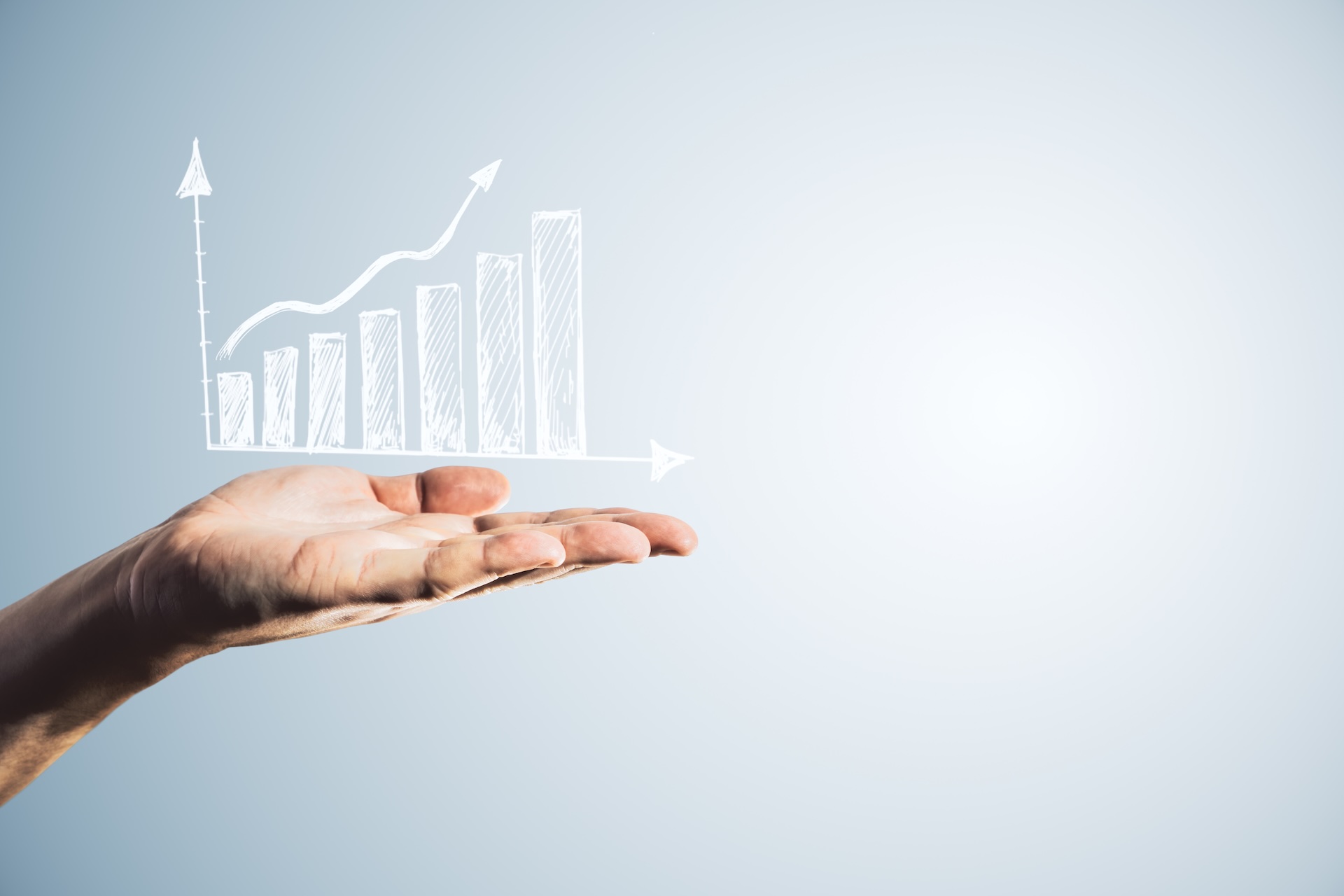 Side view of male hand holding white growing business chart on light background with mock up place. Ad, financial growth and marketing concept.